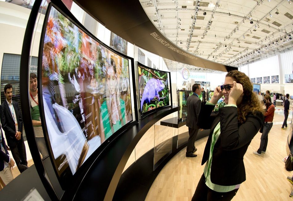 A woman looks at a curved OLED TV screen with 3D glasses at the booth of electronics giant Samsung at the 53rd IFA electronics trade fair (Internationale Funkausstellung) in Berlin on September 5, 2013. IFA, Europe's largest consumer electronics and home appliances fair opens on September 6 to September 11, 2013.  AFP PHOTO / ODD ANDERSEN        (Photo credit should read ODD ANDERSEN/AFP/Getty Images)